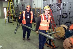 Electricians Install Various Sizes of Conduit in the Electrical Room.
8,900 cubic yards of high activity low-level waste material will be removed from Silos 1 and 2, processed and shipped off site for disposal. The material was generated from 1951 to 1960 as a waste by-product from the processing of high-grade uranium ores. The Silos 1 and 2 material, also known as K-65 material, contains radium and thorium radionuclides. Waste Retrieval Project will consist of six major systems; Silos Waste Retrieval System; Decant Sump Waste Retrieval System; Transfer Tank Area; Transfer Tank Waste Retrieval System; Radon Control System; and the Full Scale Mock-up System. Once the waste is removed from the silos it will then be stabilized with a formulation of flyash and Portland cement before being containerized for shipment. 
Keywords: Fernald Closure Project Fernald Green Salt Plant, Feed Materials Production Center, Fernald, Ohio (FEMP)