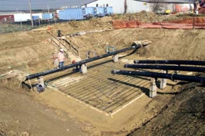 An Iron Worker Installs Rebar at Valve House 7.
A balanced approach to waste disposition has been developed at Fernald, one in which the majority of the site's contaminated material will be placed in an On-Site Disposal Facility (OSDF) for its final disposition, where as, a smaller volume of more highly contaminated waste will be sent off site. The OSDF is being constructed on the east side of the Fernald Site and will ulimately hold approximately 2.5 million cubic yards of impacted material. The facility is being constructed in phases. Phase V consists of waste placement in Cells 3, 4, 5 and 6, construction of the Cell 7 and 8 liners, the placement of the final cover on all remaining cells and screening of clay liner and cover material in the Borrow Area. 
Keywords: Fernald Closure Project Fernald Green Salt Plant, Feed Materials Production Center, Fernald, Ohio (FEMP)