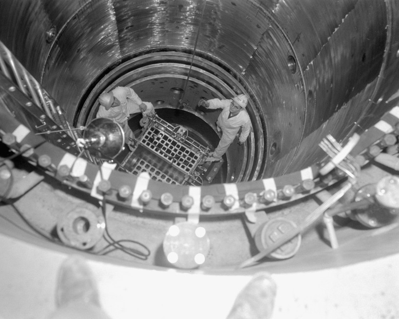 Technicians work to install the core in the Plum Brook Reactor.
Technicians work to install the core in the Plum Brook Reactor. The men are standing on the un-fueled core  which resembles a series of boxes at the center of the photo  in the steel pressure tank, which was sealed when the reactor was running. The 32-foot pressure tank was enclosed by 3 feet of concrete and water filled quadrants.
