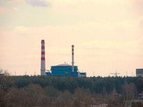 Khmelnitskiy plant two chimneys above trees at dusk